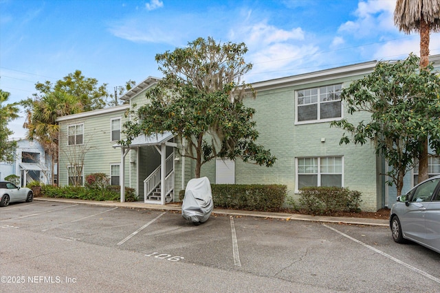 view of property with entry steps and uncovered parking