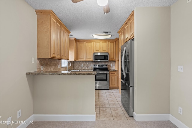 kitchen with stainless steel appliances, tasteful backsplash, a peninsula, and visible vents