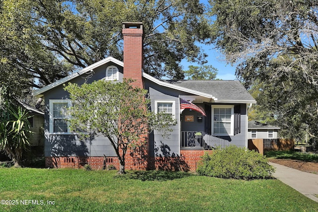 bungalow-style home featuring a shingled roof, a front yard, crawl space, and a chimney