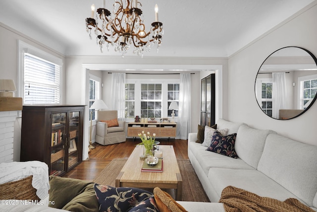 living room featuring a notable chandelier, wood finished floors, and crown molding