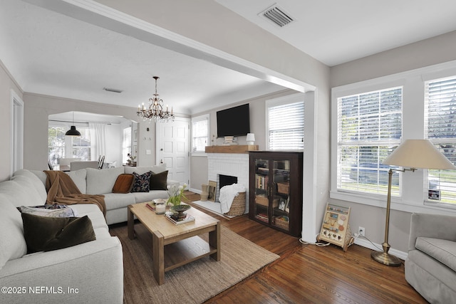 living room with wood finished floors, visible vents, and a healthy amount of sunlight