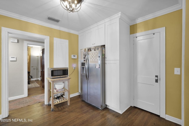 kitchen featuring visible vents, dark wood-style floors, ornamental molding, stainless steel appliances, and white cabinetry