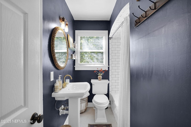 bathroom with tile patterned flooring, shower / bath combination, and toilet