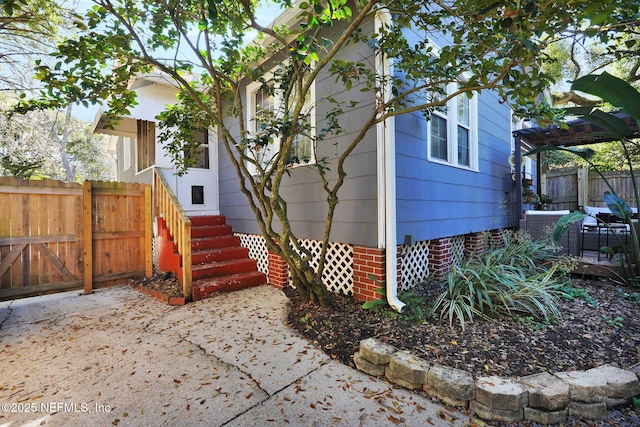 view of front facade with entry steps, crawl space, and fence