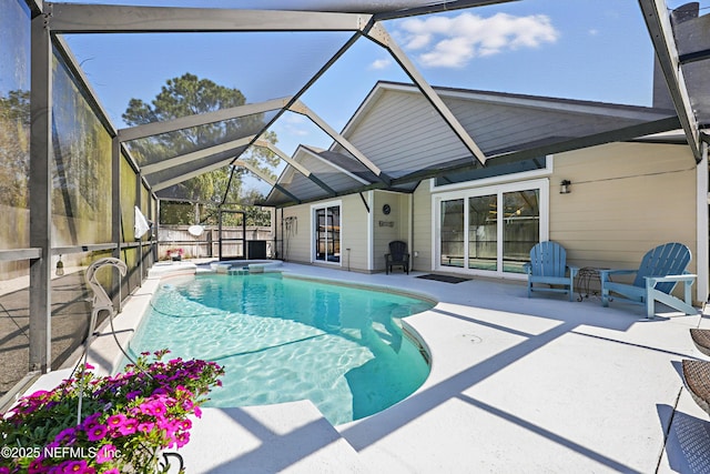 view of pool featuring a patio, glass enclosure, an in ground hot tub, fence, and a fenced in pool