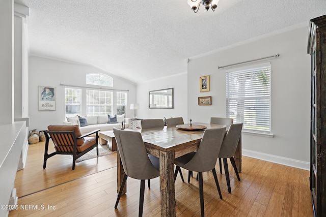 dining room featuring light wood-style floors, crown molding, and a textured ceiling