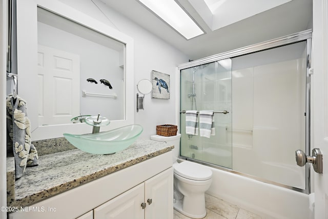 full bath featuring tile patterned floors, vanity, toilet, and bath / shower combo with glass door