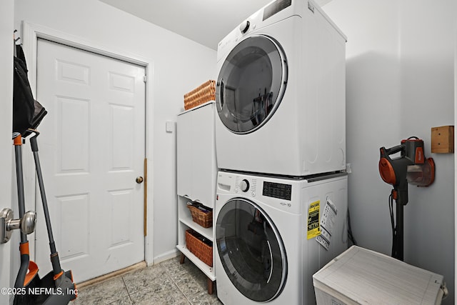 clothes washing area featuring stacked washing maching and dryer, light tile patterned floors, and laundry area