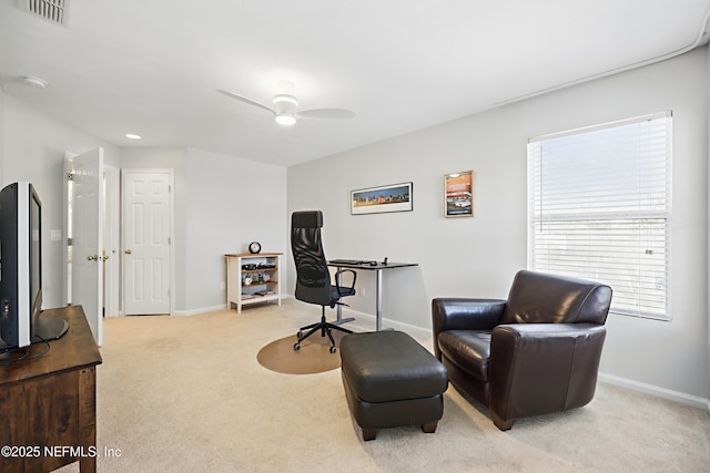 home office featuring baseboards, visible vents, ceiling fan, and light colored carpet