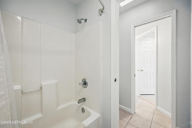 bathroom featuring bathtub / shower combination, tile patterned flooring, and baseboards