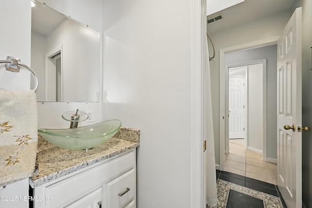 bathroom with baseboards, vanity, visible vents, and tile patterned floors