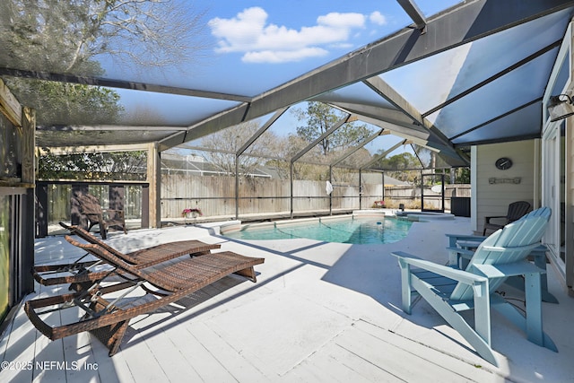 view of swimming pool featuring a patio, glass enclosure, a fenced backyard, and a fenced in pool