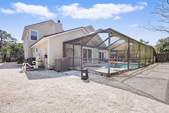 back of property with central AC unit, a fenced in pool, a lanai, fence, and a patio area