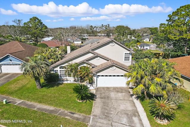 view of front of property with a garage, driveway, a front lawn, and stucco siding