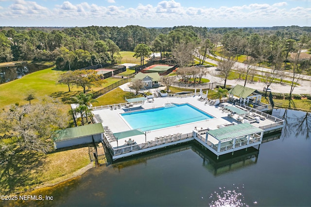 birds eye view of property featuring a water view and a wooded view