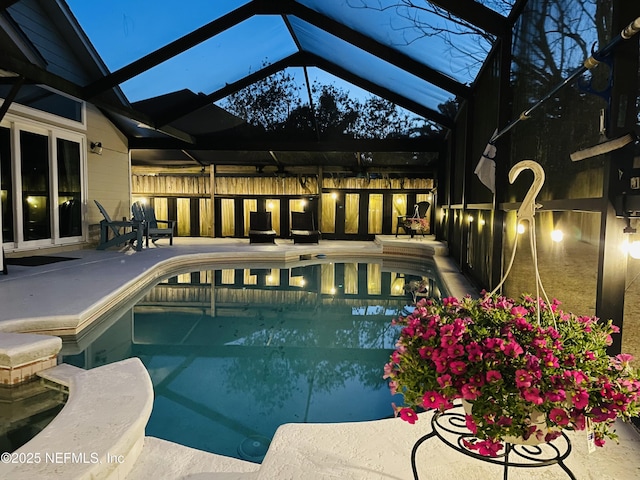 pool featuring glass enclosure and a patio area