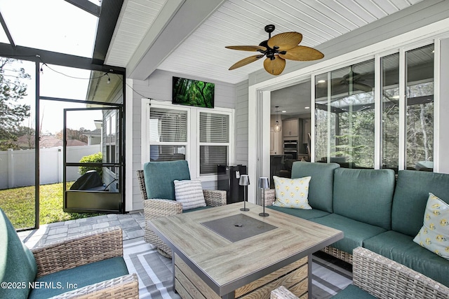 sunroom / solarium with ceiling fan, beam ceiling, wooden ceiling, and a wealth of natural light