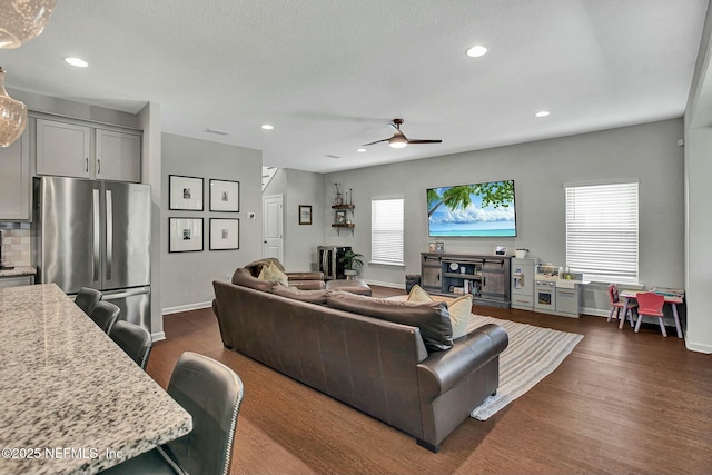 living room with dark wood-type flooring, a wealth of natural light, and recessed lighting