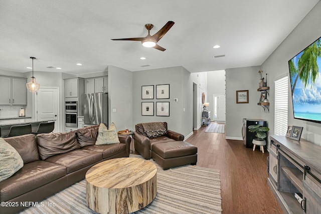 living room featuring baseboards, ceiling fan, wood finished floors, and recessed lighting