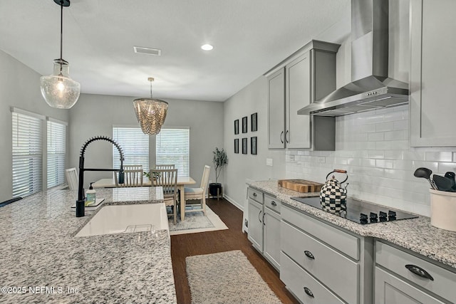 kitchen with visible vents, backsplash, a sink, wall chimney exhaust hood, and black electric cooktop