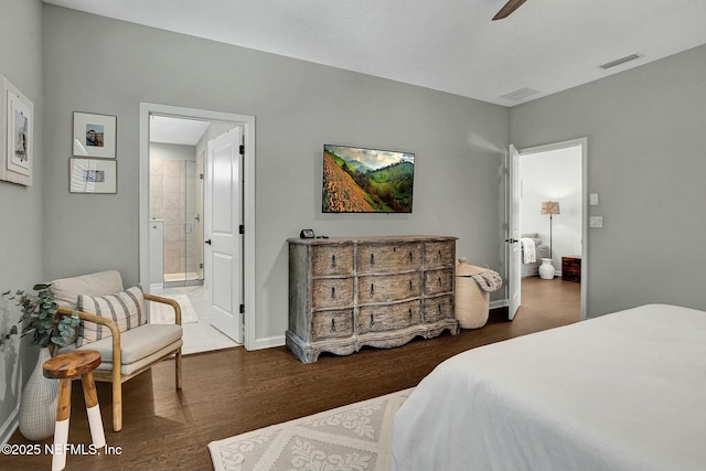 bedroom with ceiling fan, connected bathroom, wood finished floors, visible vents, and baseboards