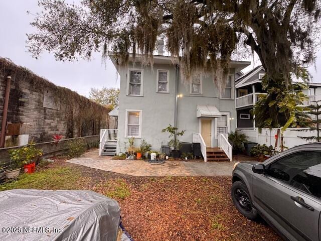 view of front facade featuring a fenced backyard and stucco siding