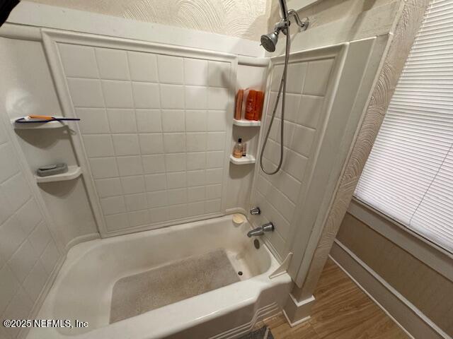 full bath featuring wood finished floors and shower / bathing tub combination