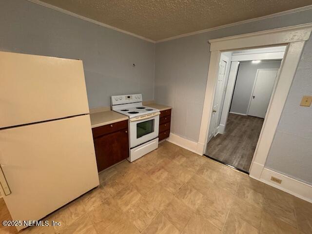 kitchen featuring ornamental molding, white appliances, light countertops, and a textured ceiling