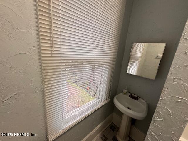 bathroom with a sink and a textured wall