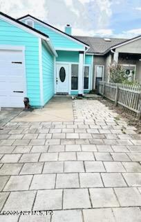 view of patio with a garage, driveway, and fence