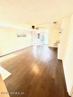 unfurnished living room with dark wood-style floors and ceiling fan