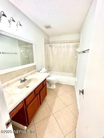 bathroom featuring toilet, shower / tub combo with curtain, tile patterned floors, a textured ceiling, and vanity