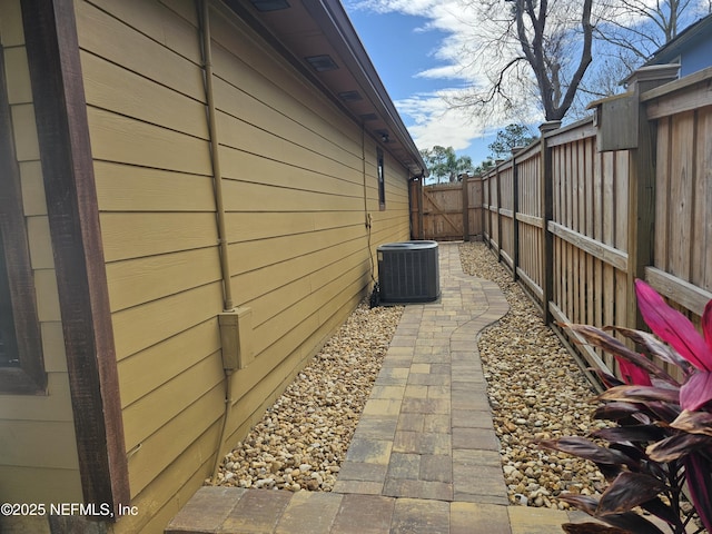 view of property exterior with a fenced backyard, a gate, and central air condition unit