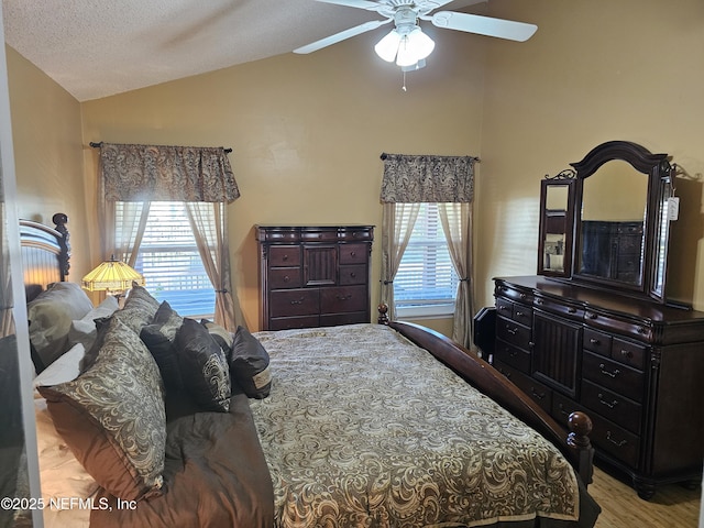 bedroom featuring lofted ceiling, ceiling fan, multiple windows, and wood finished floors