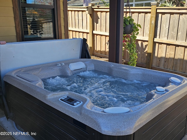 deck featuring fence and a hot tub