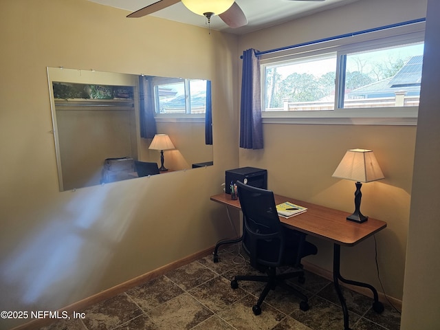 office with stone finish floor, a ceiling fan, and baseboards