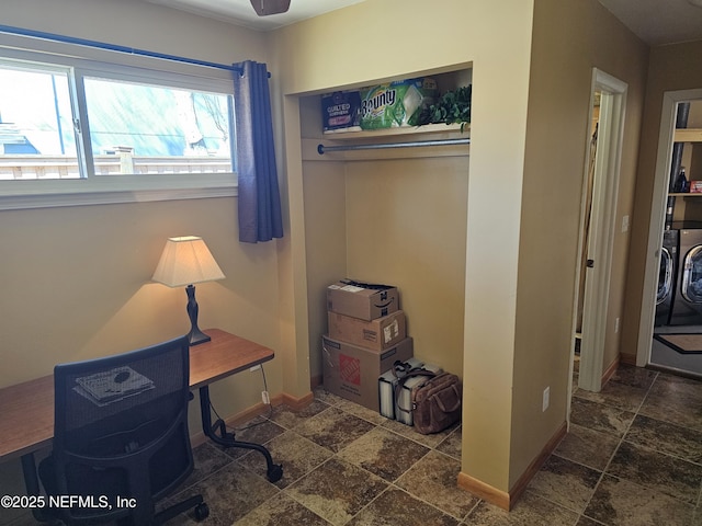 office space featuring stone tile floors, baseboards, and washing machine and clothes dryer