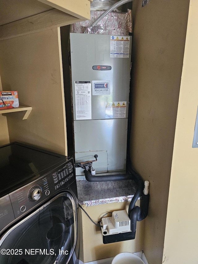 clothes washing area featuring washer / clothes dryer, heating unit, and laundry area