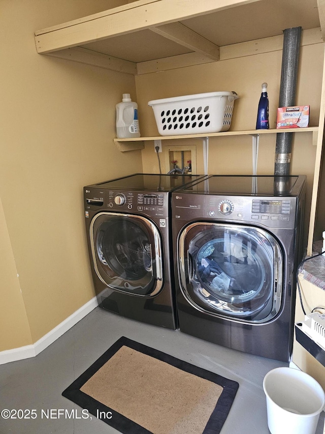 laundry room with laundry area, baseboards, and washer and clothes dryer