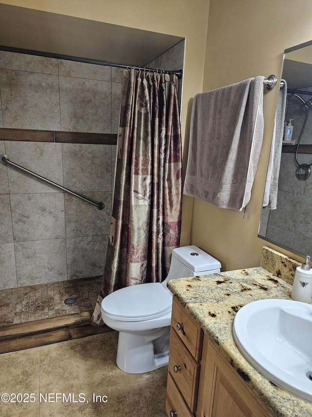 full bath featuring vanity, tile patterned flooring, a tile shower, and toilet