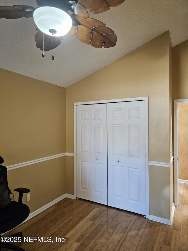 unfurnished room with vaulted ceiling, wood finished floors, and baseboards