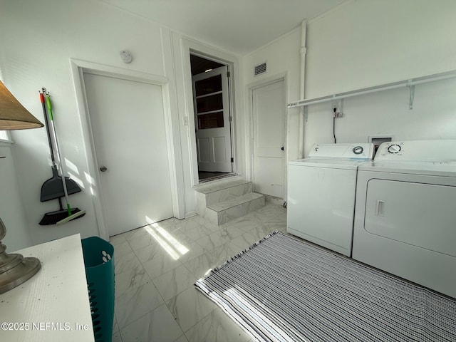 clothes washing area featuring laundry area, visible vents, marble finish floor, and washer and dryer