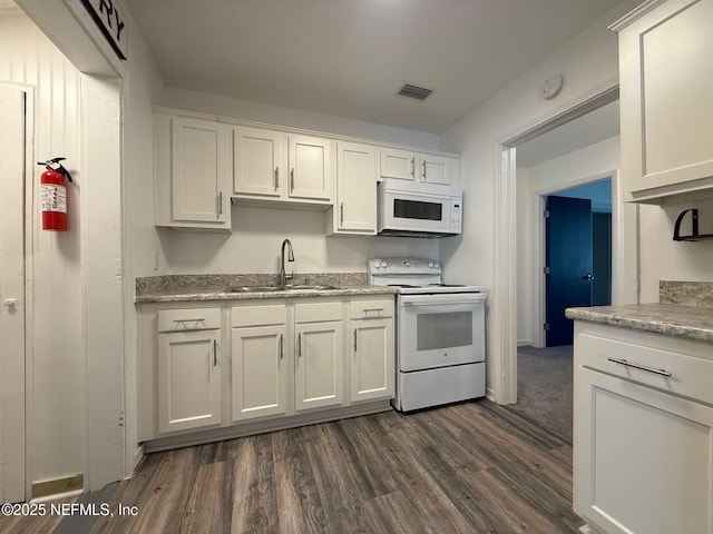 kitchen with white appliances, a sink, visible vents, white cabinets, and light countertops