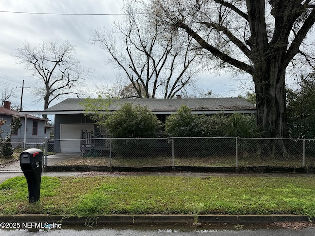 view of front facade featuring a fenced front yard, a front yard, and driveway