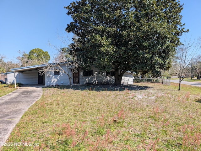 view of front of property featuring an attached carport, driveway, a front lawn, and fence