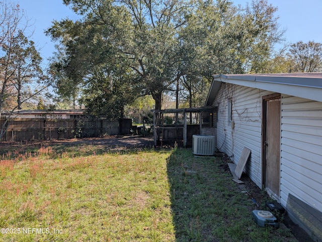 view of yard featuring central AC unit and fence