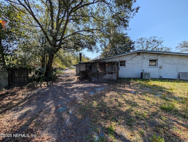 back of property featuring central AC and fence