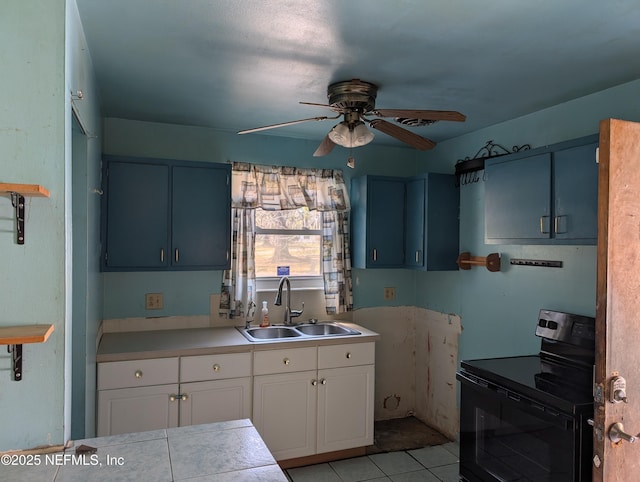 kitchen with light countertops, black electric range oven, white cabinets, a sink, and blue cabinets