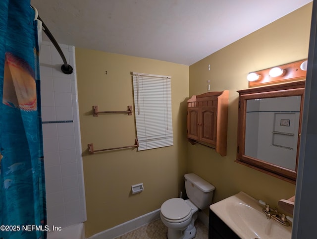 bathroom with baseboards, vanity, and toilet