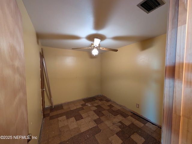 empty room with dark floors, visible vents, and ceiling fan